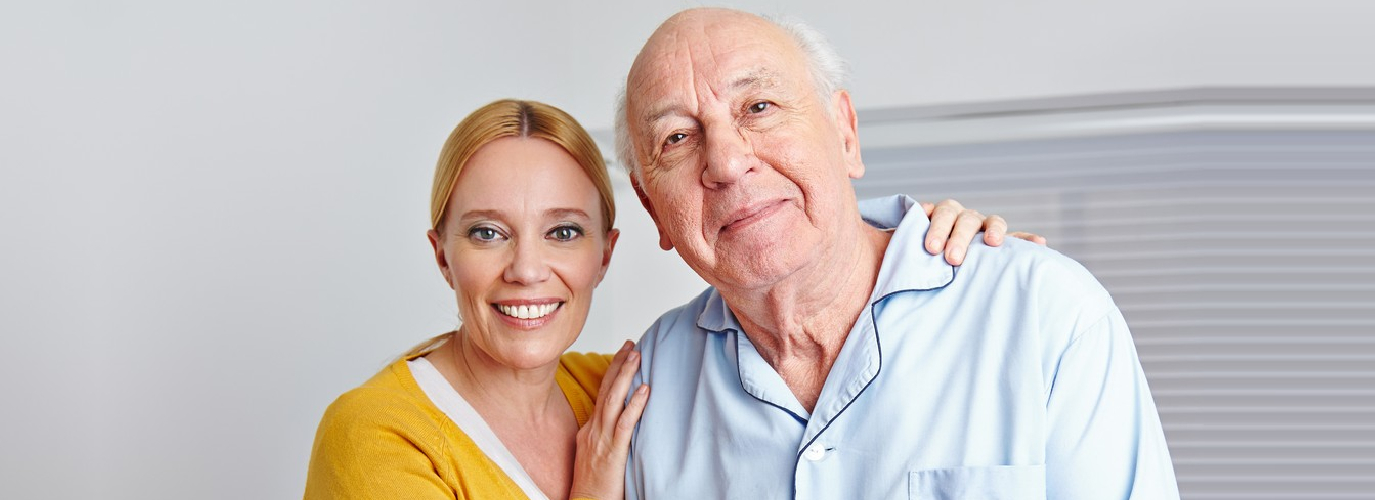 beautiful caregiver hugging senior man indoor