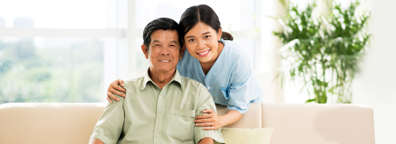 female caregiver hugging senior man